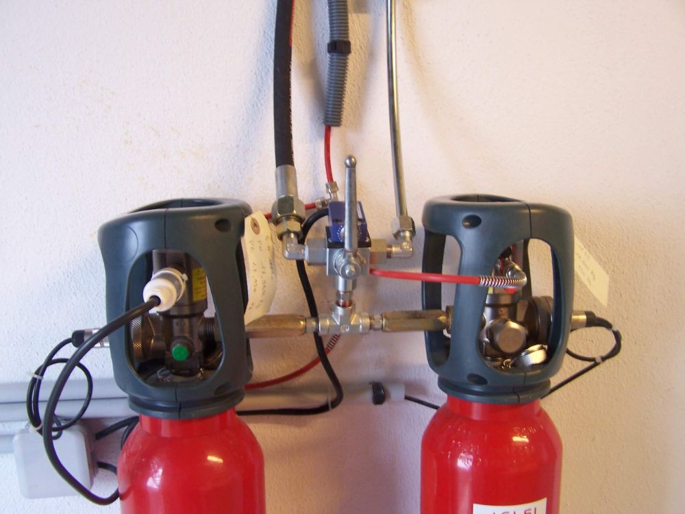SYSTEME INDIRECT D'EXTINCTION AUTOMATIQUE TRACEFLAM POUR LA PROTECTION D'UNE ARMOIRE ELECTRIQUE cette installation est composée de 2 bouteilles de CO² qui sont continuellement surveillées par le système électronique DIMES permettant la mesure simultanée et en temps réel du contenu des bouteilles de CO². Ce système permet la protection d'une armoire électrique dans laquelle on a installé le tube Firedetec (détecteur de feux réalisé en polymères spéciaux qui réagit lorsqu'un feu se déclare et atteint le tube, la paroi du conduit s'amincit) le CO² est alors diffusé par l'intermédiaire d'une rampe de diffusion avec tromblons, garantissant une extinction rapide