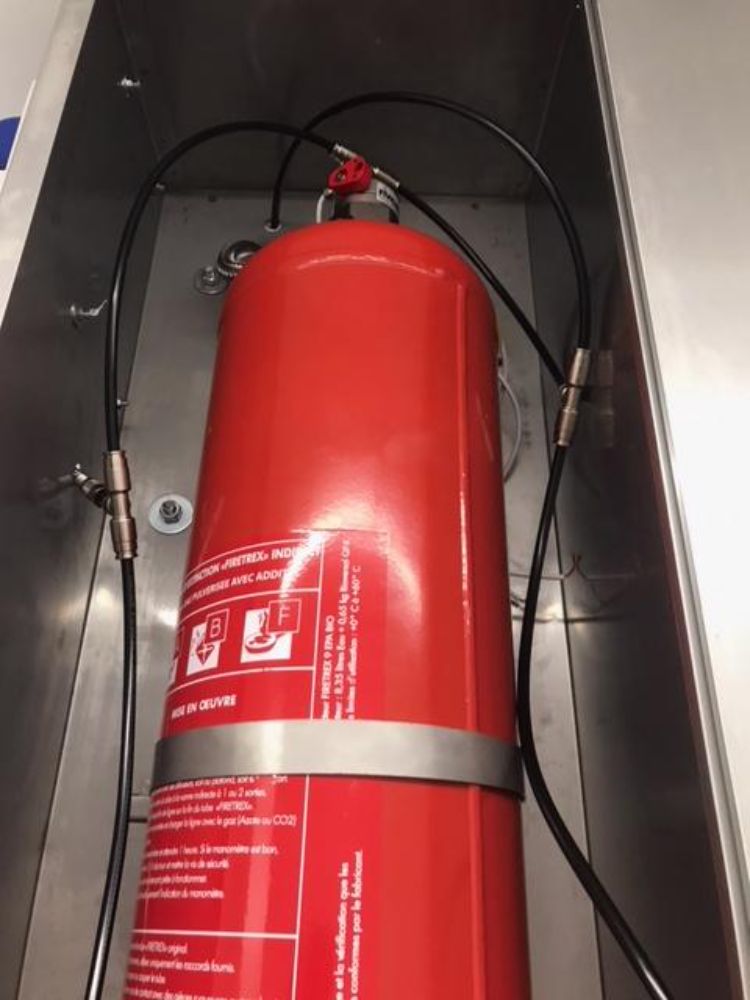 On retrouve ici une installation d'un système d'extinction automatique TRACEFLAM, pour la protection des friteuses et de la hotte aspirante.