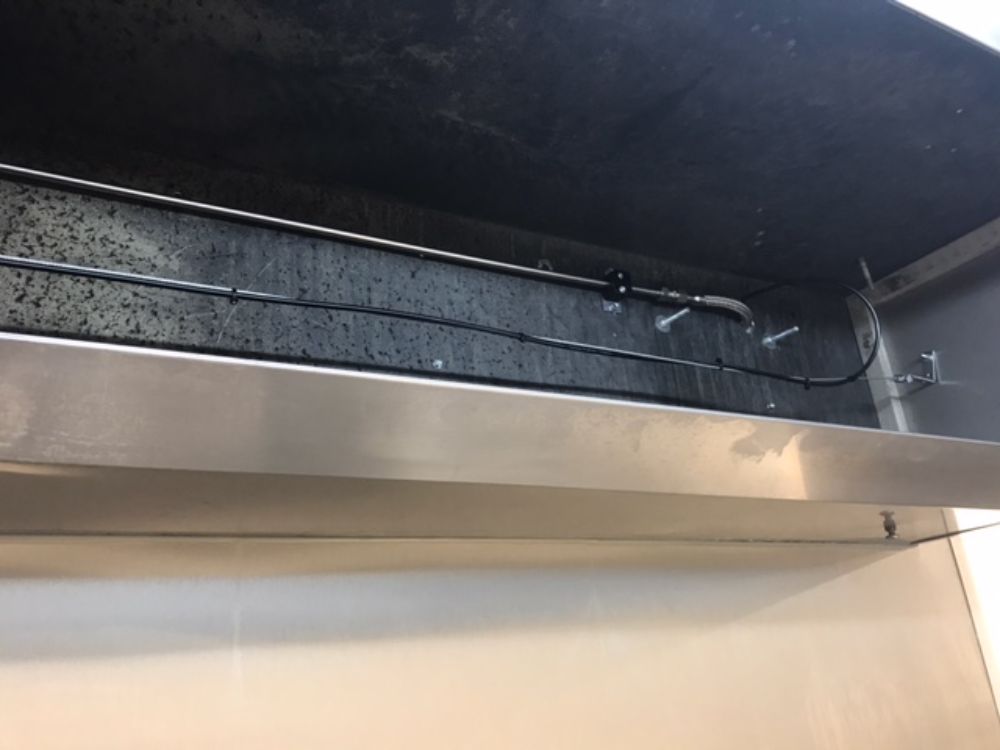 On retrouve ici une installation d'un système d'extinction automatique TRACEFLAM, pour la protection des friteuses et de la hotte aspirante.