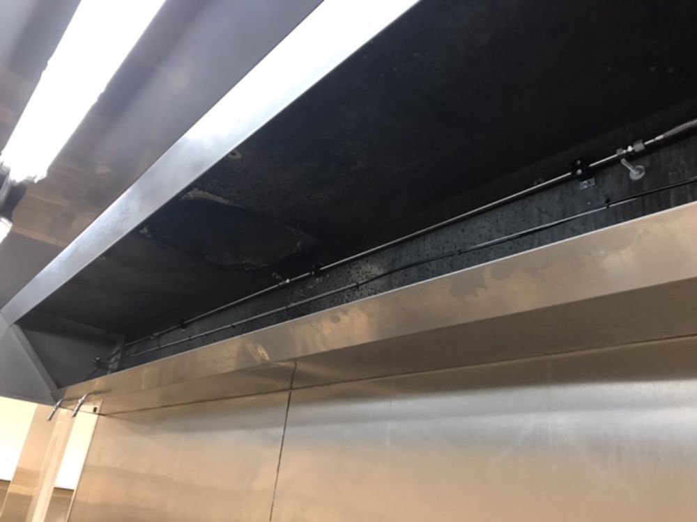 On retrouve ici une installation d'un système d'extinction automatique TRACEFLAM, pour la protection des friteuses et de la hotte aspirante.