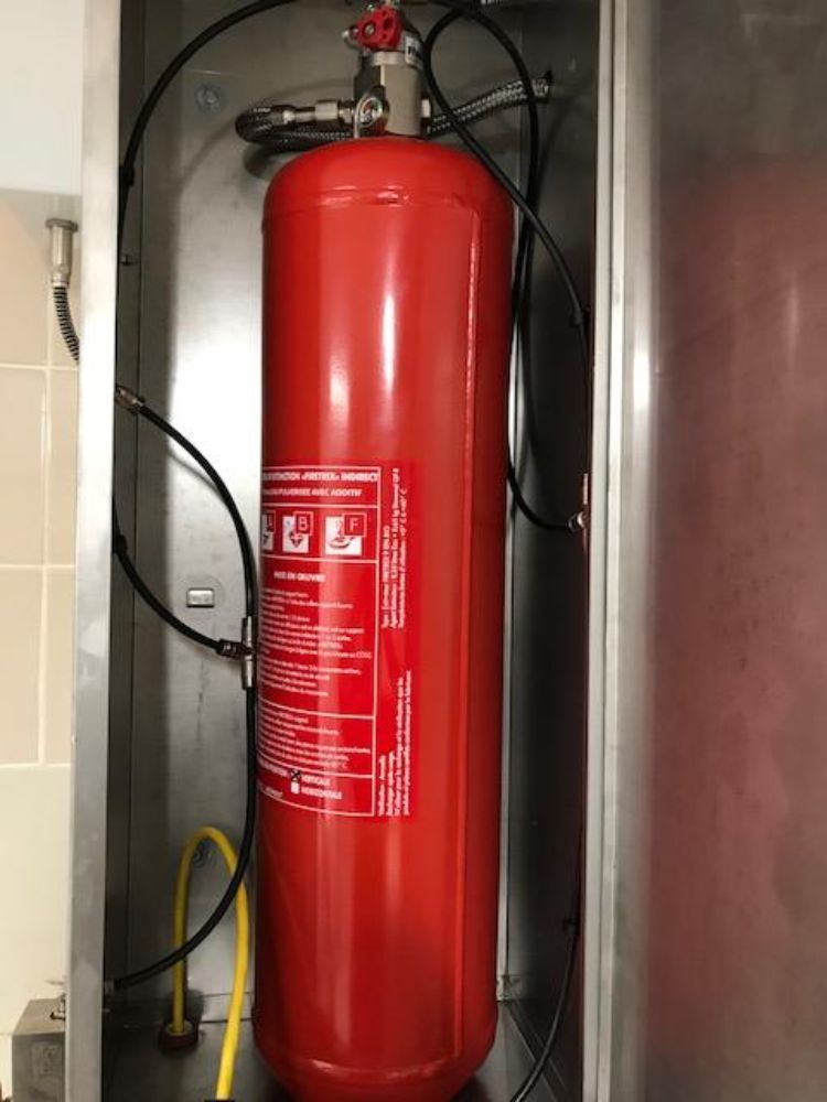 On retrouve ici une installation d'un système d'extinction automatique TRACEFLAM, pour la protection des friteuses et de la hotte aspirante.